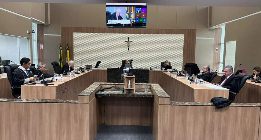A imagem mostra uma sala de sessões com mesas em formato de “U”, no TRE-CE. Há desembargadores s...