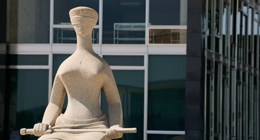 Imagem da escultura A Justiça, posicionada em frente ao edifício do STF. A escultura, em pedra, ...