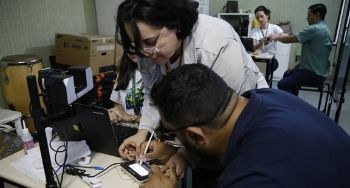 ação de cidadania no Instituto Cearense de Educação de Surdos Servidora auxilia eleitor com deficiência visual para cadastro de biometria