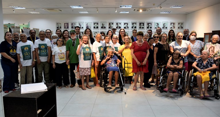 Na primeira foto, um grupo de cerca de trinta pessoas está reunido no Centro de Memória do TRE-C...