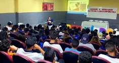 Foto mostra Edna Saboia ministrando à plateia de alunos da escola 