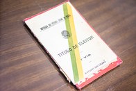 O título, com uma capa dura, é mostrado fechado, dobrado em quatro partes.