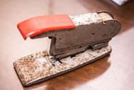 Grampeador marca Bates. Esta peça inclui um rolo de arame o qual, quando o grampeador era pressi...