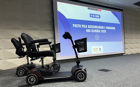 Na primeira foto, no auditório, um grupo de pessoas posa para foto diante de uma tela de projeçã...