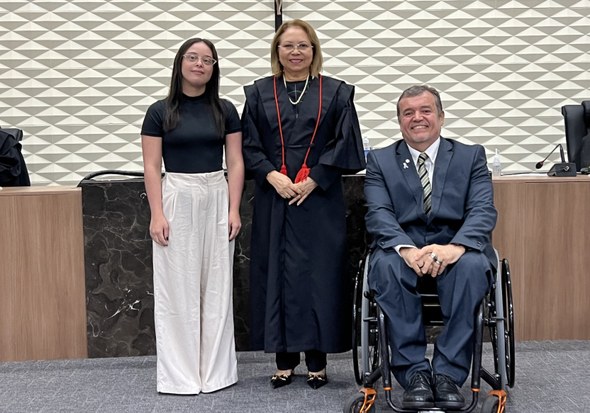 Na primeira foto, no auditório, um grupo de pessoas posa para foto diante de uma tela de projeçã...