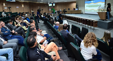 Foto vista panorâmica diagonal do auditório durante auditoria. A plateia está acomodada em poltr...