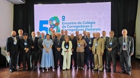 A  imagem mostra um grupo de pessoas, entre homens e mulheres, reunido para uma foto sobre o pal...