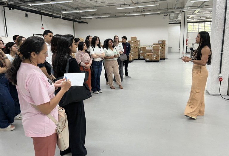 Na imagem, registrada no Depósito de Urnas do TRE-CE, há um grupo de pessoas reunido em pé, volt...