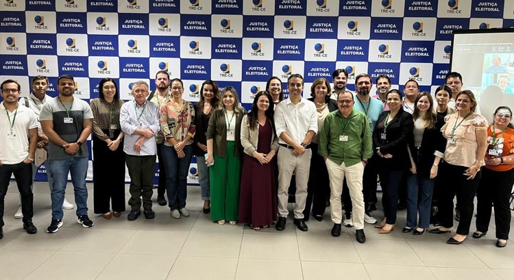 Na  imagem, os participantes do curso, entre homens e mulheres, estão em pé posando para a foto....