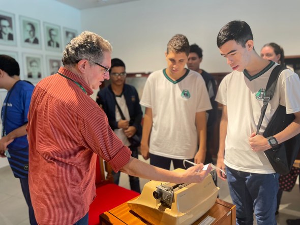 Registro fotográfico feito no Centro de Memória. Nele, há o servidor Vasco, manuseando uma máqui...