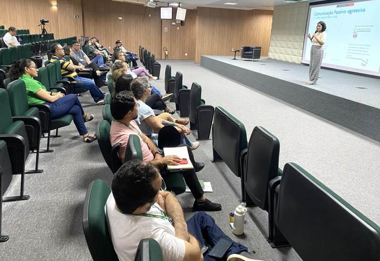 Corpo funcional do TRE-CE aprimora, em curso, habilidades de comunicação com eleitores(as) e colegas de trabalho Na imagem, os servidores estão sentados em poltronas. Mostra ainda a palestrante Tatiane Silva n...