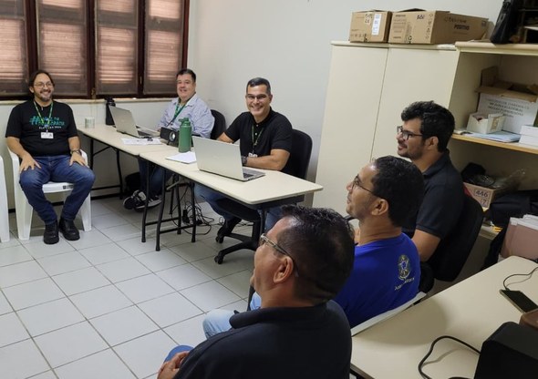 Corregedoria do TRE-CE conclui semana de visitas técnicas em zonas eleitorais da Região Norte do Estado Cinco pessoas estão em uma sala de escritório, com divisórias ao fundo separando ambientes. Quat...