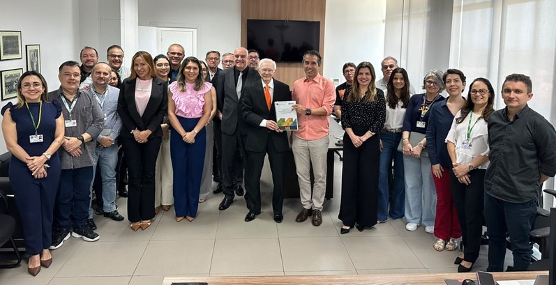 A imagem mostra um grupo de pessoas na vice-prediência do TRE-CE. O grupo está em pé, disposta e...