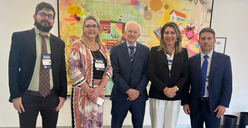 Na imagem estão presentes cinco pessoas - três homens e duas mulheres - posando para a foto.
