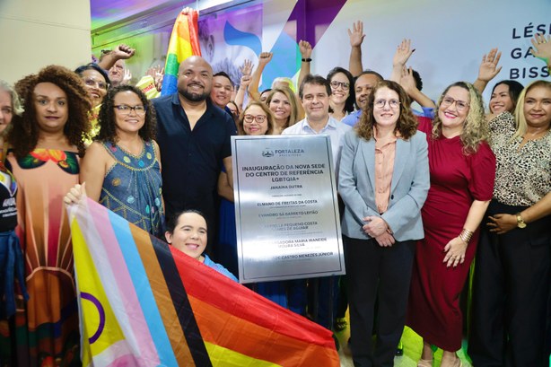 A imagem mostra um grupo de pessoas reunidas em um ambiente interno durante uma cerimônia de ina...