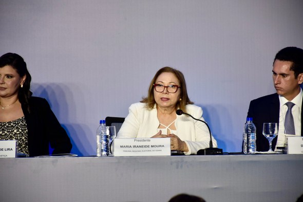 A imagem mostra a desembargadora Maria Iraneide enquanto fala ao microfone, sentada na mesa de h...