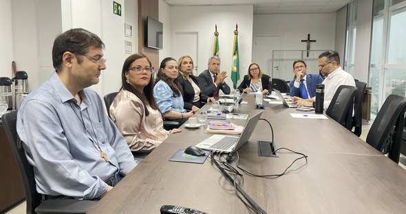 A terceira imagem mostra a mesa de forma mais ampla, com o grupo de oito pessoas sentado em cade...