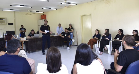 IMG_2710.JPG A terceira imagem retrata uma reunião em sala ampla, com servidores e voluntários reunidos em fo...