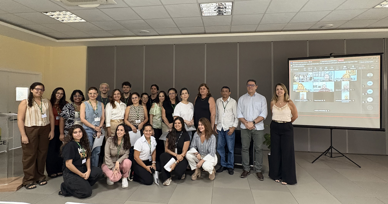 Na imagem, mostra um grupo de pessoas posando para foto, delas, 17 estão em pé, e cinco estão ag...