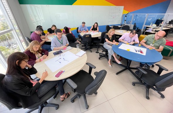 Jornada “Inove-se!” aproxima unidades do TRE-CE ao Laboratório de Inovação Na última imagem, há participantes sentados, engajados em uma das dinâmicas da programação.