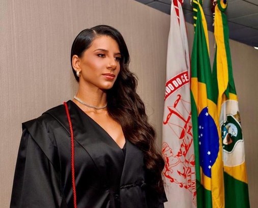 Juíza de Boa Viagem concede certidão de quitação eleitoral por tempo inderteminado a eleitor com TEA A imagem mostra uma mulher em pé, vestindo uma beca preta com detalhe em cordão vermelho no ombr...