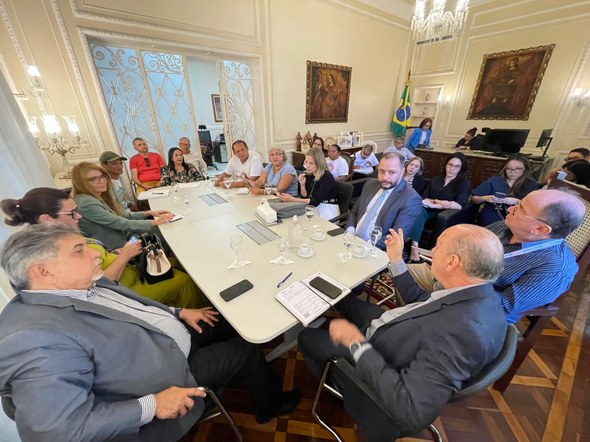 Justiça e cidadania: PopRuaJud - Ceará dá início às ações de 2025 A imagem mostra uma reunião com pessoas sentadas ao redor de uma mesa retangular