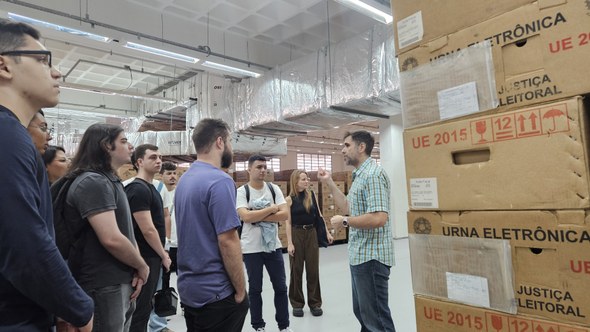 Laboratório de Inovação do TRE-CE inicia atividades no campus da Unifor Em primeiro plano, há uma pilha de caixas de papelão, com descrições "UE 2015 | Urna eletrônica"...