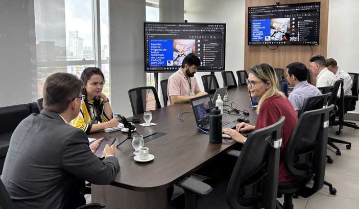 A primeira imagem mostra uma sala de reuniões com uma mesa retangular cercada por servidores par...