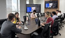 A primeira imagem mostra uma sala de reuniões com uma mesa retangular cercada por servidores par...