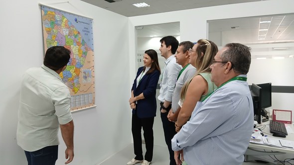 Na primeira foto, os novos servidores estão sentados em cadeiras de escritório, enquanto assiste...