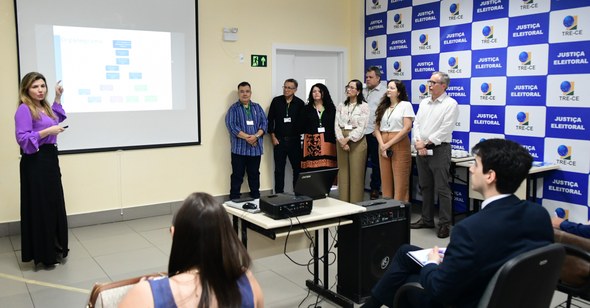 Na primeira foto, os novos servidores estão sentados em cadeiras de escritório, enquanto assiste...