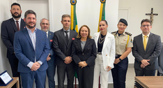 A imagem mostra um grupo de pessoas na sala da Presidência do TRE-CE, posicionadas lado a lado e...