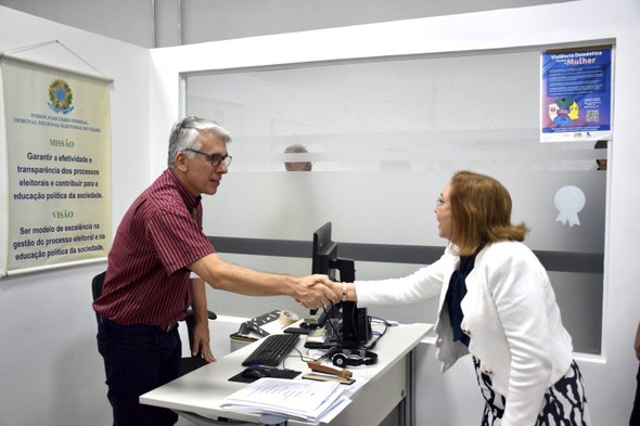 Presidência do TRE-CE reforça compromisso em reformar sede dos cartórios da capital A imagem mostra a presidente do TRE-CE cumprimentando um servidor com um aperto de mãos.