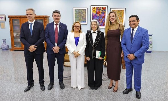 Na primeira imagem, várias pessoas estão sentadas lado a lado em uma mesa, entre elas as preside...