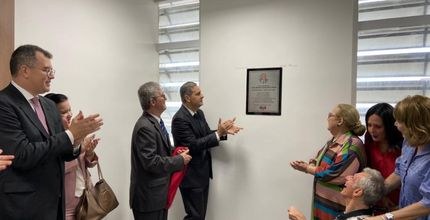 Foto tirada na sala de advogados da sede do TRE. Pessoas estão em pé lado a lado. Entre eles, o ...