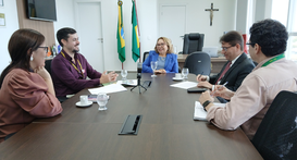 A imagem mostra uma reunião na sala da Presidência do TRE-CE. Cinco pessoas estão sentadas ao re...