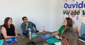 Projeto "Ouvidoria vai até você" é lançado nesta segunda-feira, 8/5 Foto tirada em sala de reunião. 11 pessoas estão sentados ao redor de mesa retangular. Ao fundo,...