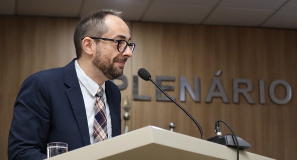 Na imagem, o servidor do TRE Ceará aparece sozinho atrás de um púlpito. Ele está de perfil, volt...