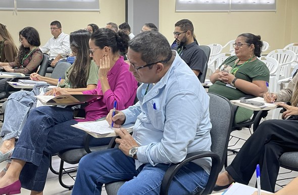 Na imagem, os participantes aparecem durante a aula, entre homens e mulheres, alguns fazendo ano...