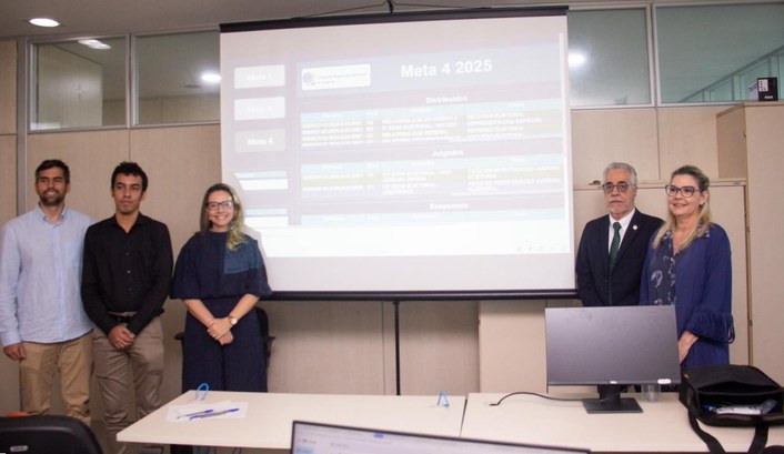 Na imagem, aparecem cinco pessoas — três homens e duas mulheres — distribuídas entre os lados es...