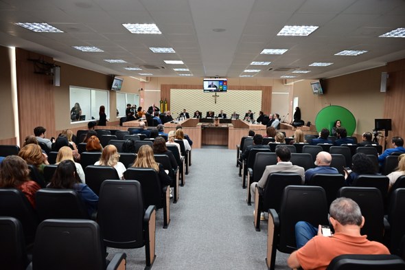 TRE-CE agracia cinco personalidades com Comenda de Mérito ao Ouvidor durante sessão solene Os registros fotográficos foram feitos no plenário do TRE-CE. Ao centro da parede, há um crucifi...