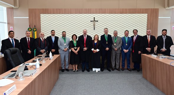 TRE-CE agracia cinco personalidades com Comenda de Mérito ao Ouvidor durante sessão solene Os registros fotográficos foram feitos no plenário do TRE-CE. Ao centro da parede, há um crucifi...