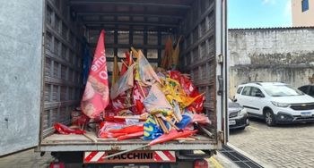 TRE-CE apreende 1.300 bandeiras em operação de fiscalização de propaganda eleitoral Foto mostra baú do caminhão com diversas bandeiras empilhadas.