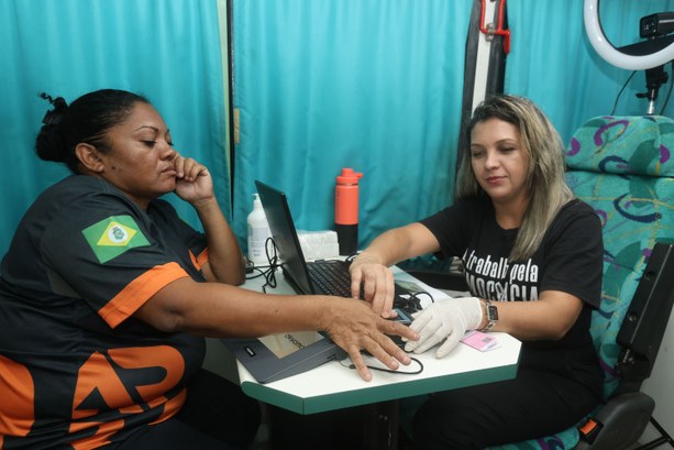 TRE-CE atende eleitores do Cais do Porto durante projeto “Nossa Casa é de Todos” da CMFor A imagem mostra um atendimento eleitoral sendo realizado dentro da Unidade Móvel do TRE-CE. Duas...