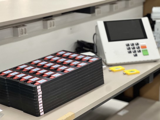 TRE-CE conclui geração de mídias das urnas para o 1º turno das Eleições 2024 Registro fotográfico feito na sede do TRE-CE. Nele, em uma bancada, há uma urna eletrônica e div...