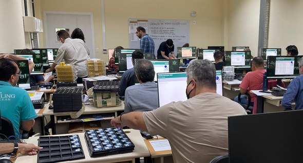 TRE-CE conclui geração de mídias das urnas para o 1º turno das Eleições 2024 Registro fotográfico feito na sede do TRE-CE. Em uma sala de paredes amarelas, estão diversos co...