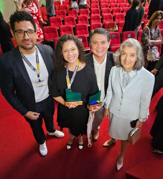 TRE-CE conquista o Ouro e Selo de Qualidade no Prêmio Justiça Eleitoral, do TSE Na imagem, três servidores da 28ª Zona Eleitoral posam para a foto ao lado da ministra Cármen Lú...