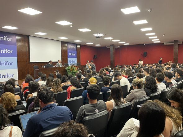 A imagem mostra o auditório durante o evento. Sobre o palco, estão o presidente do TRE-CE, desem...