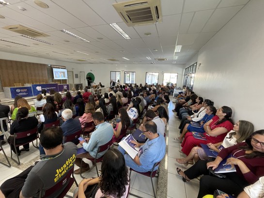 Registro feito no Fórum de Tauá. Nele, diversas pessoas estão sentadas em cadeiras enfileiradas....