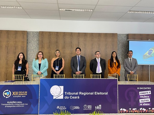 Registro fotográfico feito no Fórum de Tauá. Nele, sete pessoas estão atras de uma bancada. À fr...